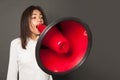 Young woman screaming with loudspeaker, cries expressing excitement, great emotion