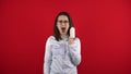 Young woman screaming with rewind bandage finger and shouts. Shooting on a red background. Royalty Free Stock Photo