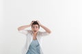 Young woman screaming in terror with hands on her head, mouth wide open looking in panic at the camera. Close up Royalty Free Stock Photo