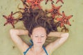 Young woman in the sea with red starfishes Royalty Free Stock Photo