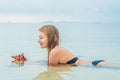 Young woman in the sea with red starfishes Royalty Free Stock Photo