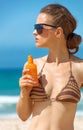 Young woman on seacoast with suntan lotion Royalty Free Stock Photo