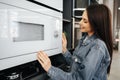Young woman selected a new microwave oven in hypermarket Royalty Free Stock Photo