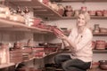 Young woman selecting ceramics with red enamel in atelier Royalty Free Stock Photo