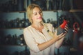 Young woman selecting ceramics with red enamel in atelier Royalty Free Stock Photo