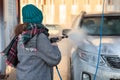 Young woman is on self-service car wash, rear view Royalty Free Stock Photo