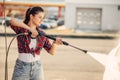 Young woman on self-service car wash