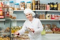 Young woman seller offering sweets Royalty Free Stock Photo