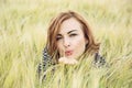Young woman send a sweet kiss in the wheat field Royalty Free Stock Photo
