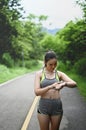 Young woman setting fitness app on her smartwatch before running session. Royalty Free Stock Photo