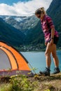 Traveling Norway, Young woman sets up tent, Beautiful view of Buerdalen Valley and Sandvevatnet Lake near city of Odda Norway