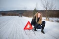 Young woman setting up a warning triangle and calling for assistence Royalty Free Stock Photo