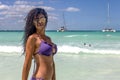 Young woman with sexy body and beautiful bikini on a tropical beach paradise enjoying the waves, water, catamaran and freedom. Royalty Free Stock Photo