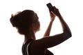 Young woman in a shade of a silhouette with phone Royalty Free Stock Photo