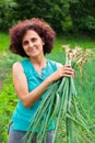 Young woman with a sheaf of young onions