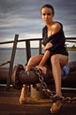 Young woman only in shirt, high heels, long legs. Metal structures, dramatic sky. fashion style