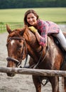 Young woman in shirt resting on brown horse after ride leaning forward, smiling - his coat wet from sweat Royalty Free Stock Photo