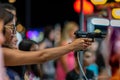 A young woman shooting with airsoft semi-automatic handgun at a fair.