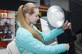 Young woman in shop phototechnique looking on spotlights Royalty Free Stock Photo