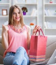 Young woman with shopping bags indoors home on sofa Royalty Free Stock Photo