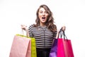 Young woman with shopping bags over white background screaming and wondering Royalty Free Stock Photo