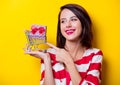 Young woman with shopping cart and gift Royalty Free Stock Photo