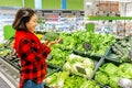 Woman shopping for fresh broccoli and greenery in supermarket Royalty Free Stock Photo