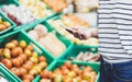 Young woman shopping healthy food in supermarket blur background. Female hands buy products tomato using smartphone in store Royalty Free Stock Photo