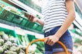 Young woman shopping healthy food in supermarket blur background. Female hands buy products and using mobile smart phone in store Royalty Free Stock Photo