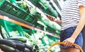 Young woman shopping healthy food in supermarket blur background. Female hands buy products and using mobile smart phone in store Royalty Free Stock Photo