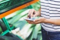 Young woman shopping healthy food in supermarket blur background. Female hands buy products and using mobile smart phone in store Royalty Free Stock Photo