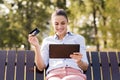 Woman shopping on-line with credit card in the park Royalty Free Stock Photo