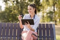 Young woman shopping on-line in the park Royalty Free Stock Photo