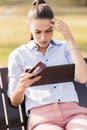 Young woman shopping on-line in the park Royalty Free Stock Photo