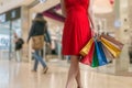 Young woman is shopping in mall and holds many colorful bags Royalty Free Stock Photo