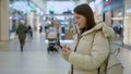 Young woman in shopping mall or trade center using smartphone mobile phone. Royalty Free Stock Photo