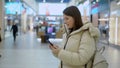 Young woman in shopping mall or trade center using smartphone mobile phone. Royalty Free Stock Photo