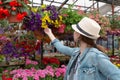 Young woman shopping in an outdoors fresh urban flowers market, buying and picking from a large variety of colorful floral Royalty Free Stock Photo