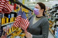 A young woman shopping in a supermarket during a virus epidemic face under the mask with coronavirus COVID-19 Royalty Free Stock Photo