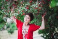 Young woman with short hair-cut standing near cherry tree Royalty Free Stock Photo