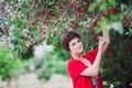 Young woman with short hair-cut standing near cherry tree Royalty Free Stock Photo