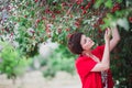 Young woman with short hair-cut standing near cherry tree Royalty Free Stock Photo