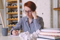 Young woman with short hair at desk writes thoughtfully in pen Royalty Free Stock Photo