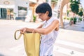 Young woman with short hair smiling happy outdoors looking at the purse