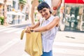 Young woman with short hair smiling happy outdoors looking at the purse