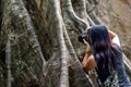 Young woman with Shoulder bag and using a camera to take photo Giant big tree, Size comparison between human and giant big tree in