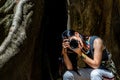 Young woman with Shoulder bag and using a camera to take photo Giant big tree, Size comparison between human and giant big tree in