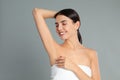 Young woman showing hairless armpit after epilation procedure on background Royalty Free Stock Photo