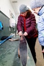 A woman showing someone how to prepare cross country skis