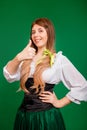 Young woman showing thumb up gesture and smiling isolated on green background. St. Patrick`s Day and Oktoberfest Royalty Free Stock Photo